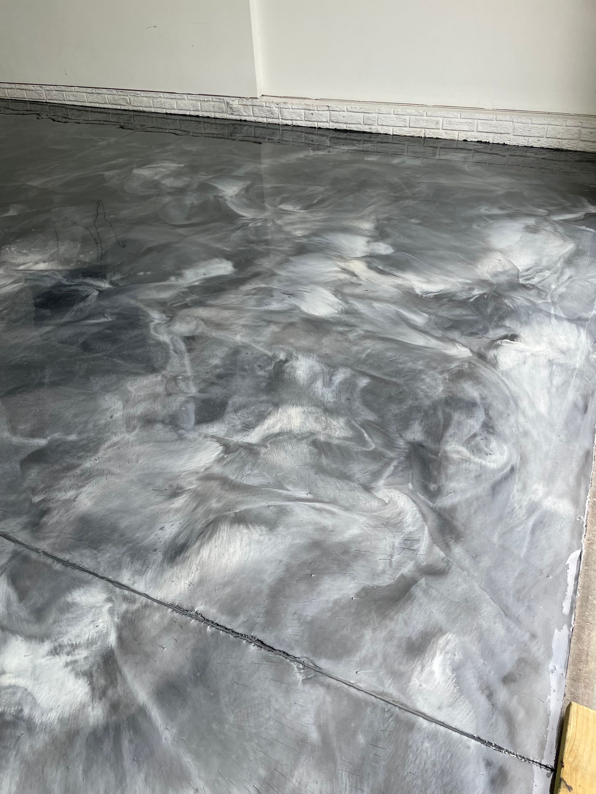 Gray and white epoxy flooring with marble effect, freshly installed in a room.