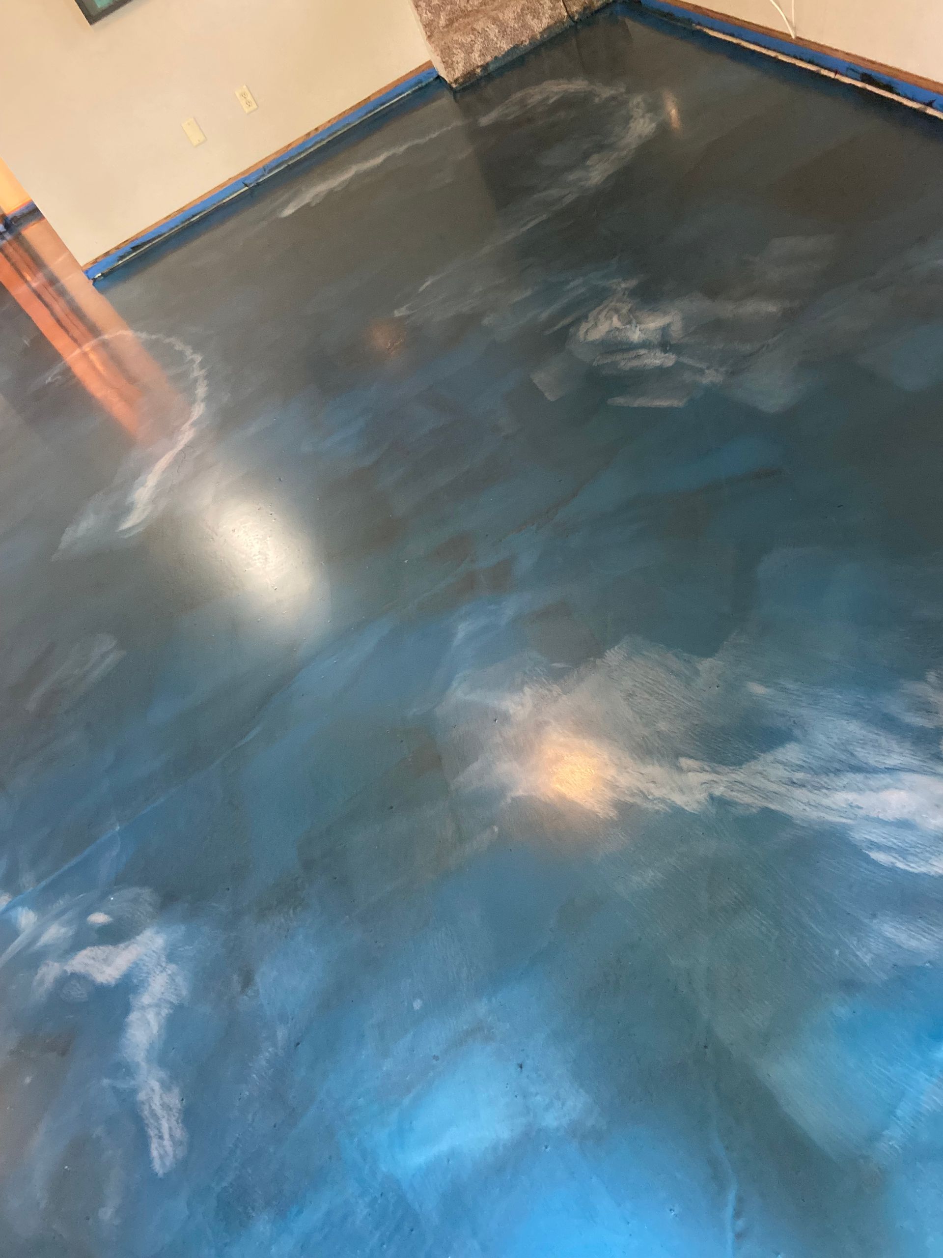 Blue and silver metallic epoxy floor with swirling patterns in a room.