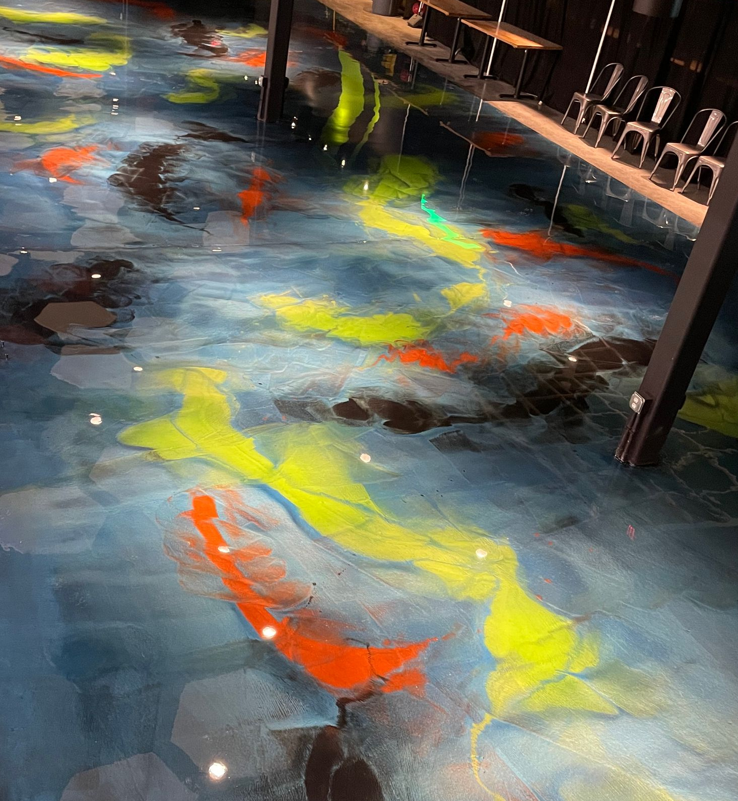 Epoxy floor with koi fish design, blue water with orange, yellow, and black fish.