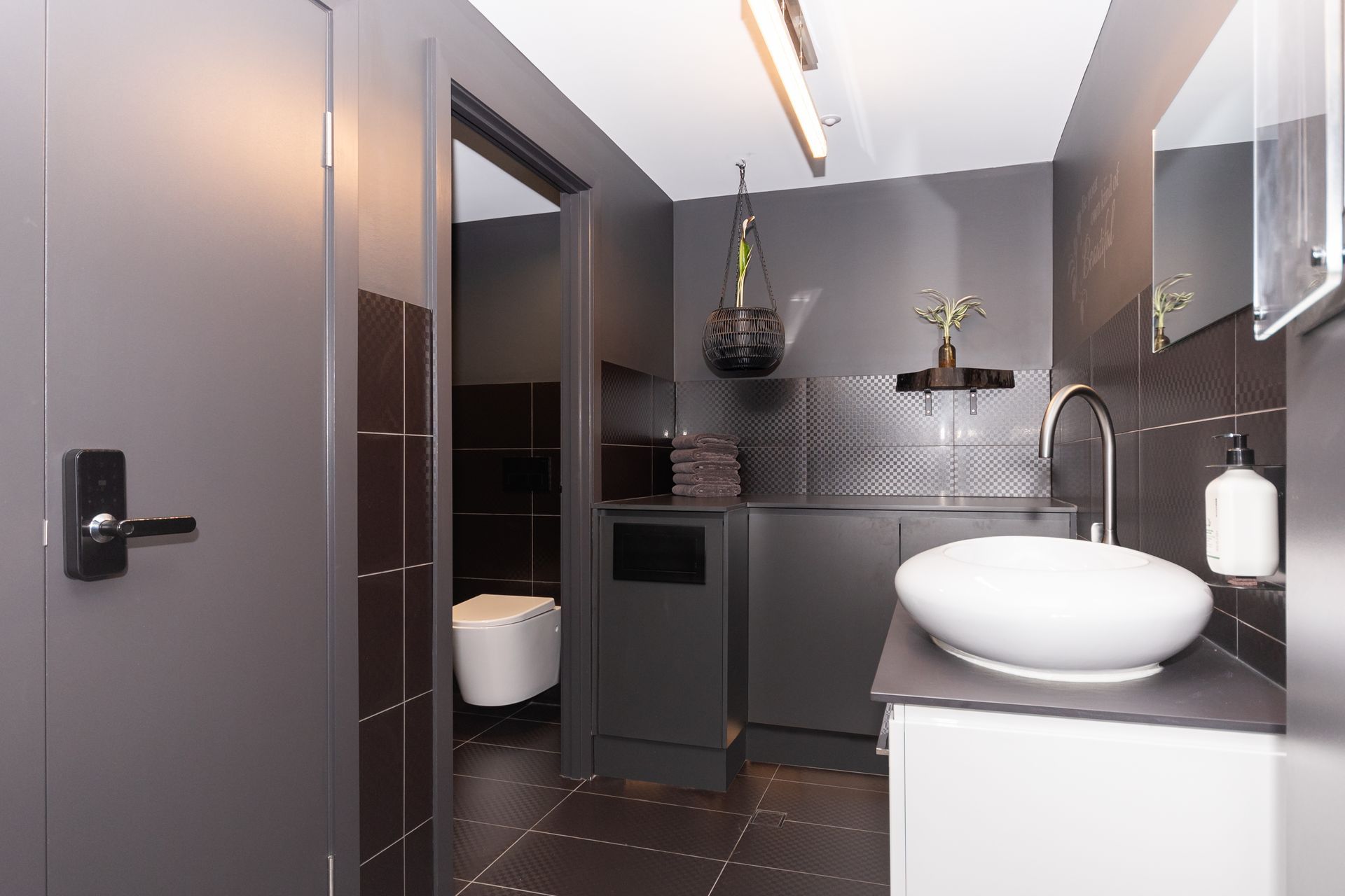 A bathroom with a sink , toilet and mirror.