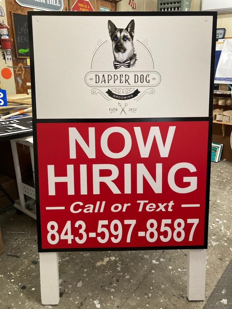 Dogger Dog sign with “NOW HIRING” in red and white, call or text 843-597-8587.