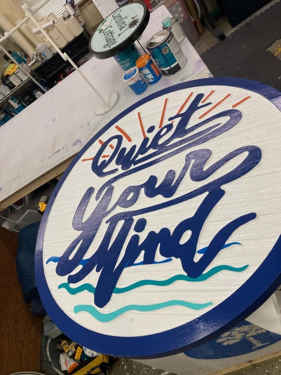 “Quiet your mind” painted on a round white-and-blue sign in a workshop.