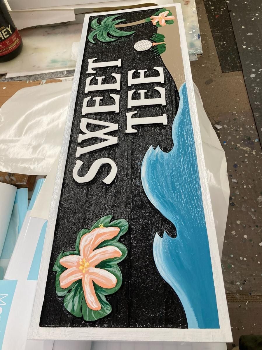 Black, blue, and white “SWEET TEE” decorated cake with palm trees and wave design