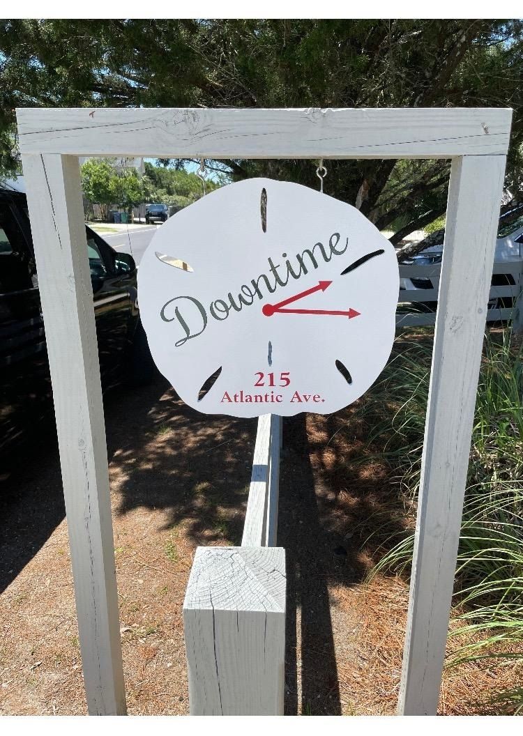 White sign reading “I Downtown” and “215 Atlantic Ave” in a wooden frame outdoors.