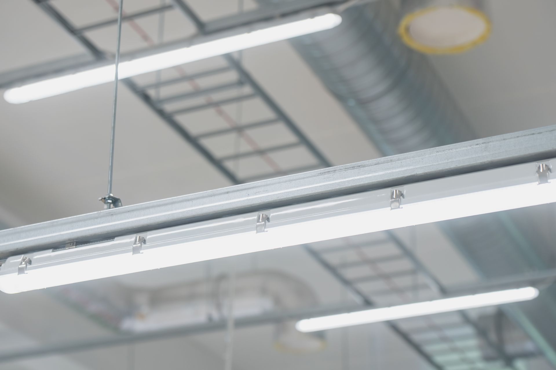 Ceiling fluorescent lights in an industrial indoor space.