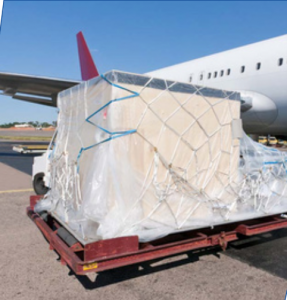 Cargo loaded on a pallet near an airplane, ready for transport.
