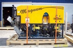 Yellow Magnum machine on a wooden pallet, secured with orange straps, ready for transport.