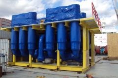 Yellow metal framed industrial equipment with blue components covered in blue tarps.