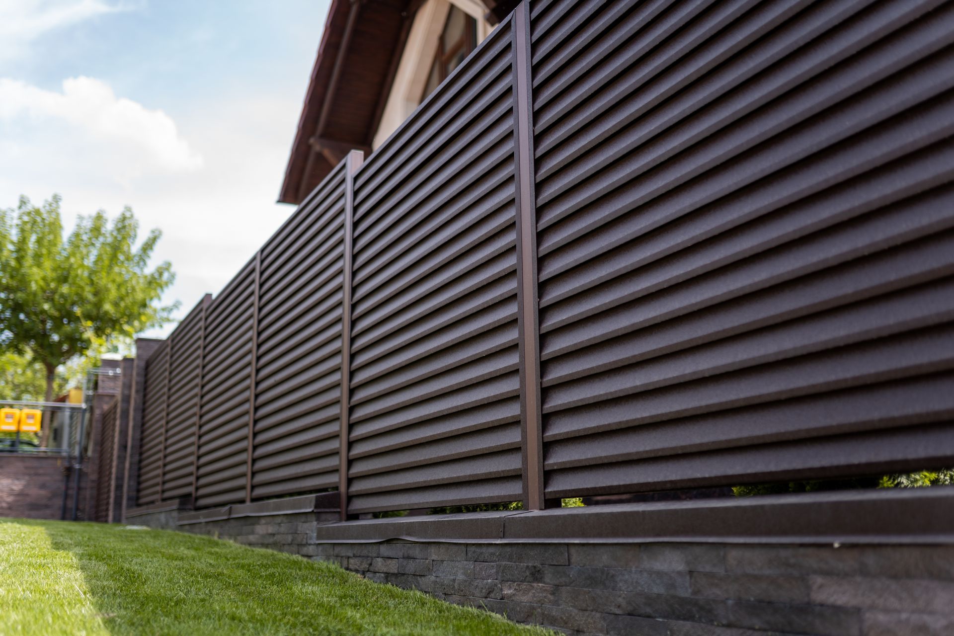 A close up of a brown fence in front of a house.