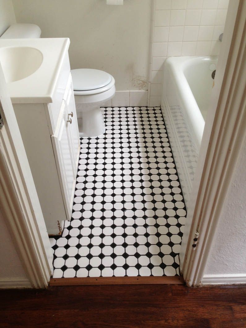 A small bathroom with a vanity, toilet, and bathtub, featuring a black-and-white grid tile floor.