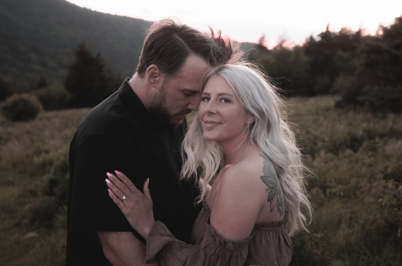 Brandon and Grace embracing in the mountains at sunset
