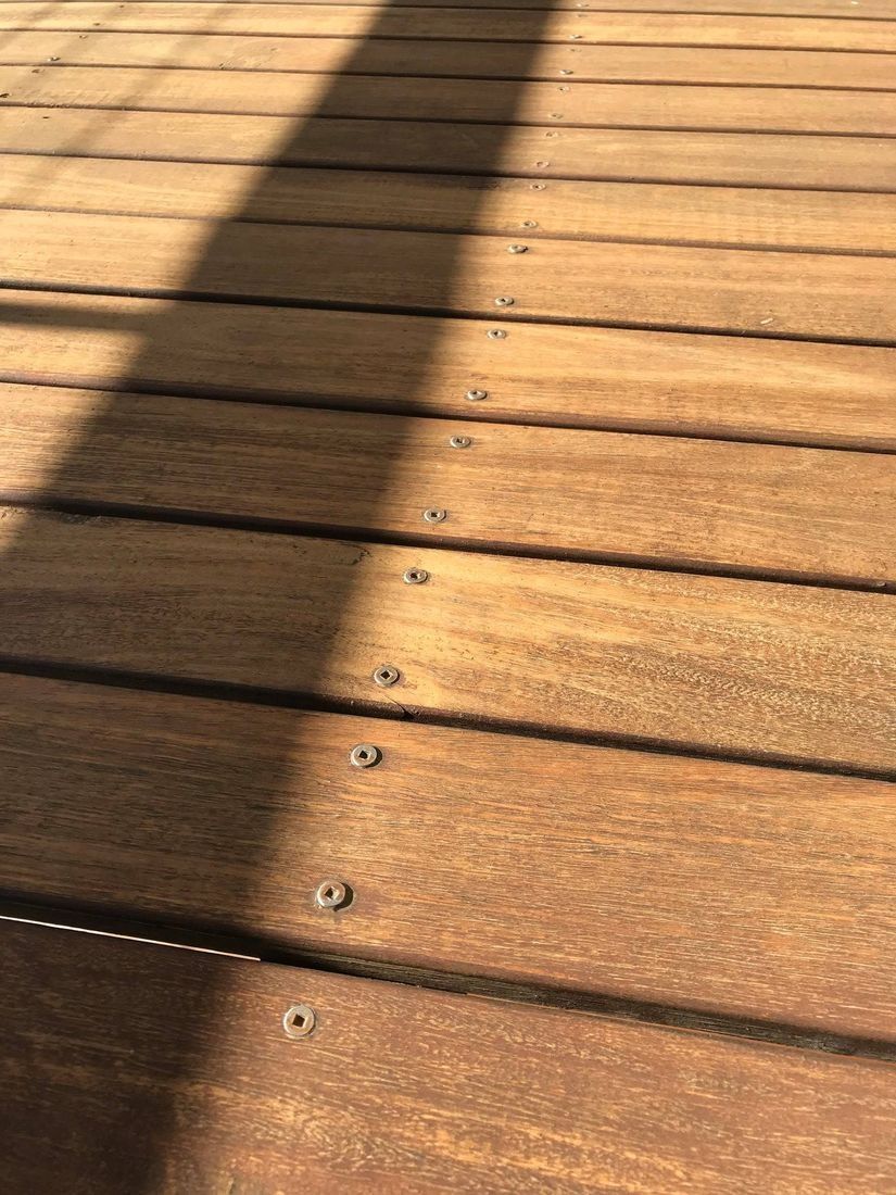 Brown Wooden Deck Planks With a Shadow Cast Across Them — Custom Floor Sanding In Gosford, NSW