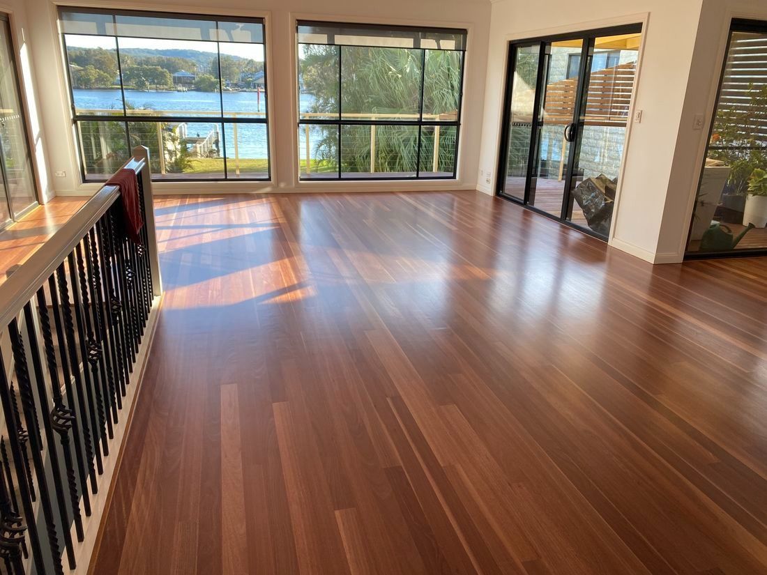Bright Room With Hardwood Floors, Large Windows Overlooking Water — Custom Floor Sanding In Gosford,