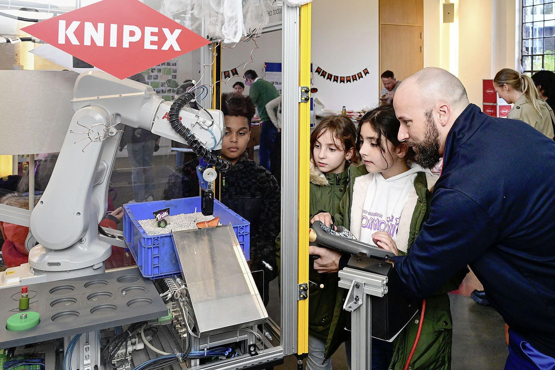 Türöffnertag bei Knipex. Ein Mitarbeiter und drei Kinder am Geschicklichkeitsspiel