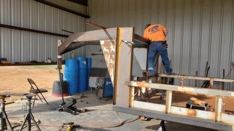 a man is welding a piece of metal in a garage .