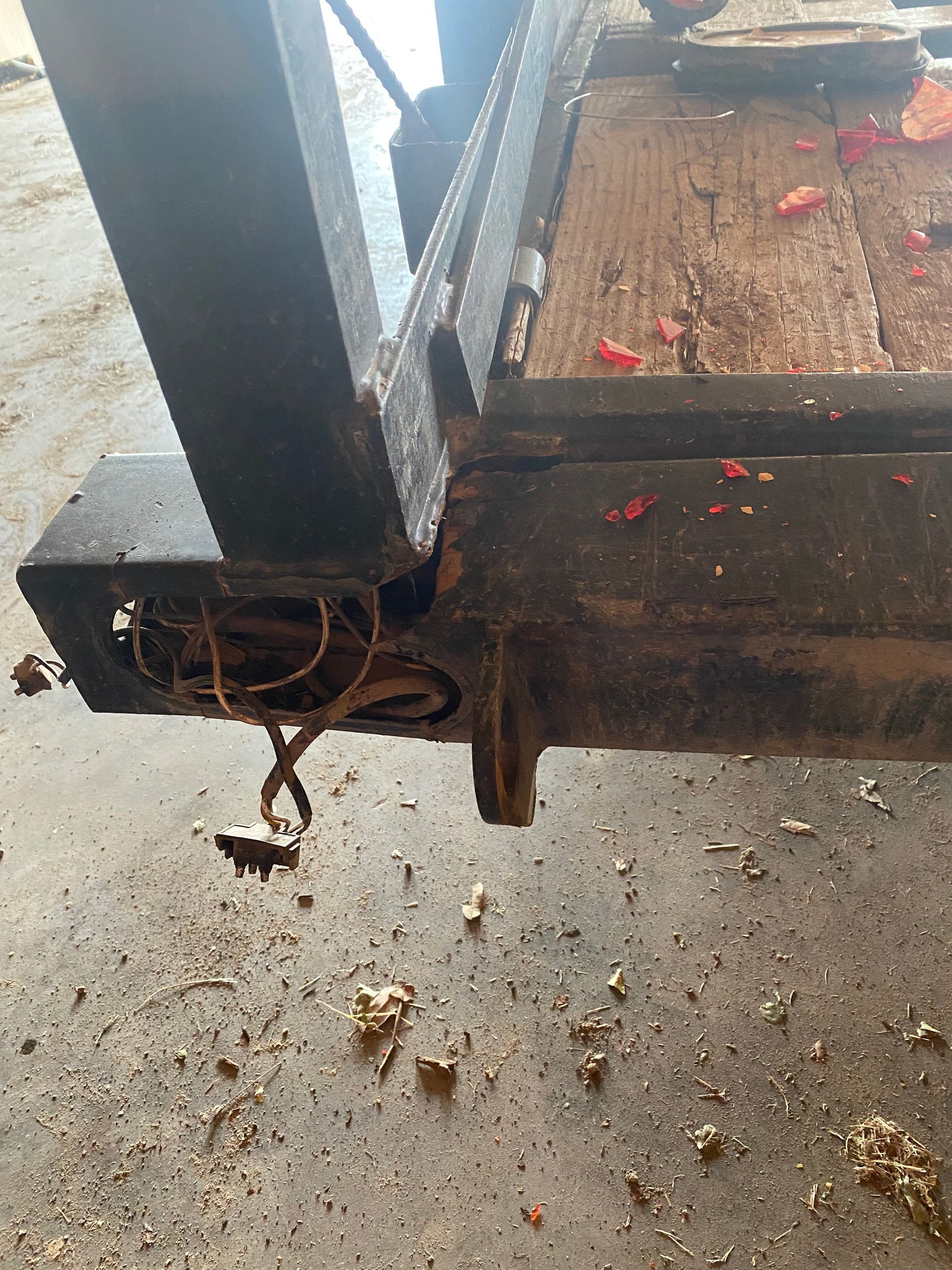 a piece of wood is laying on the ground next to a piece of metal .