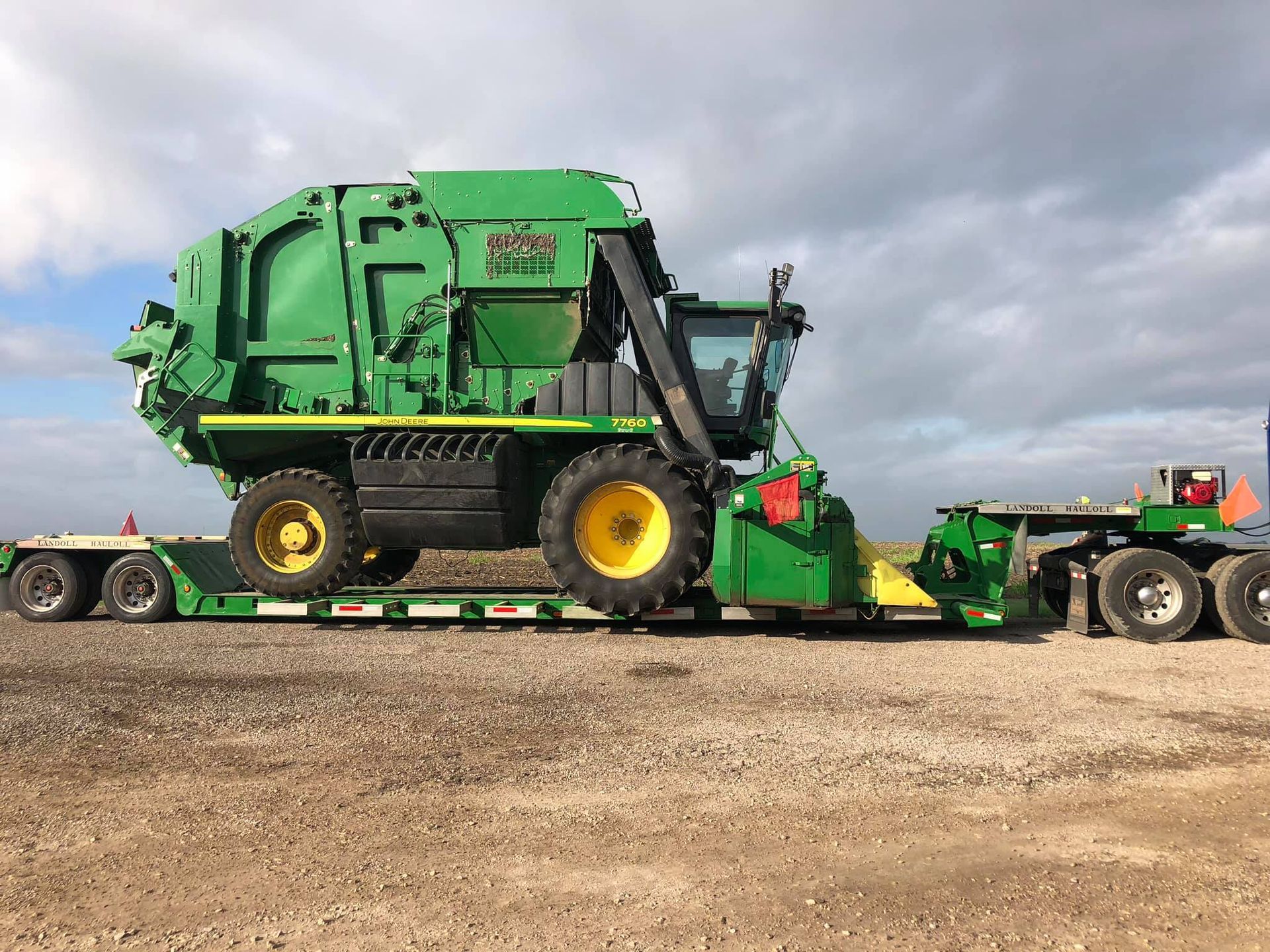 a green tractor is sitting on top of a trailer after having the Bearing And Axles repaired