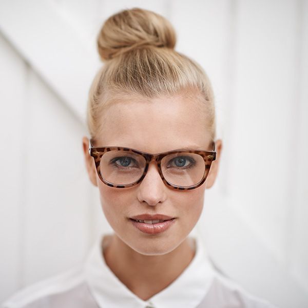 A young woman wearing a white shirt and spectacles