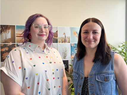 Two women are standing next to each other in a room.