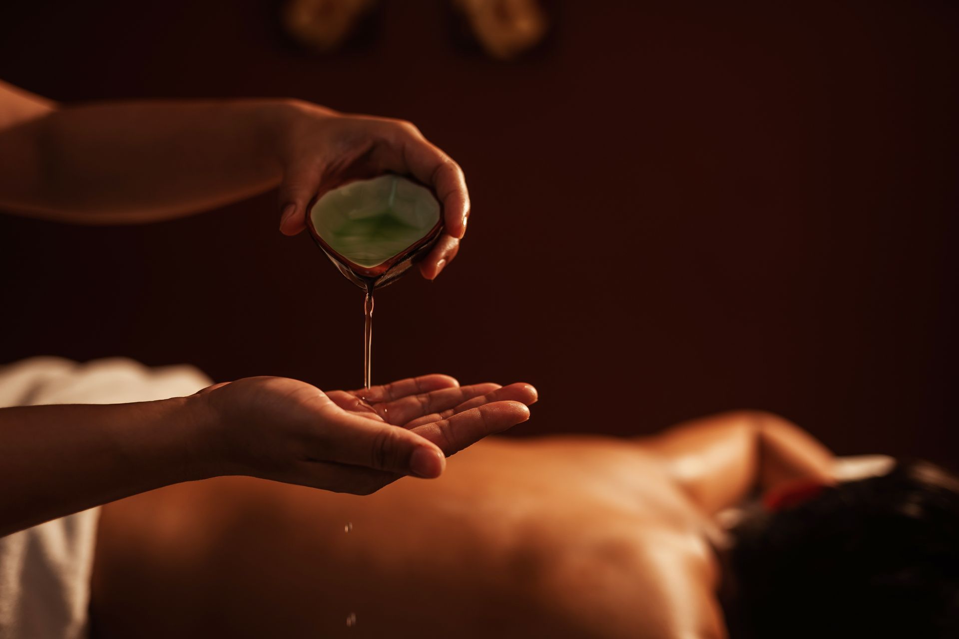 A person is getting a massage with oil on their hands.