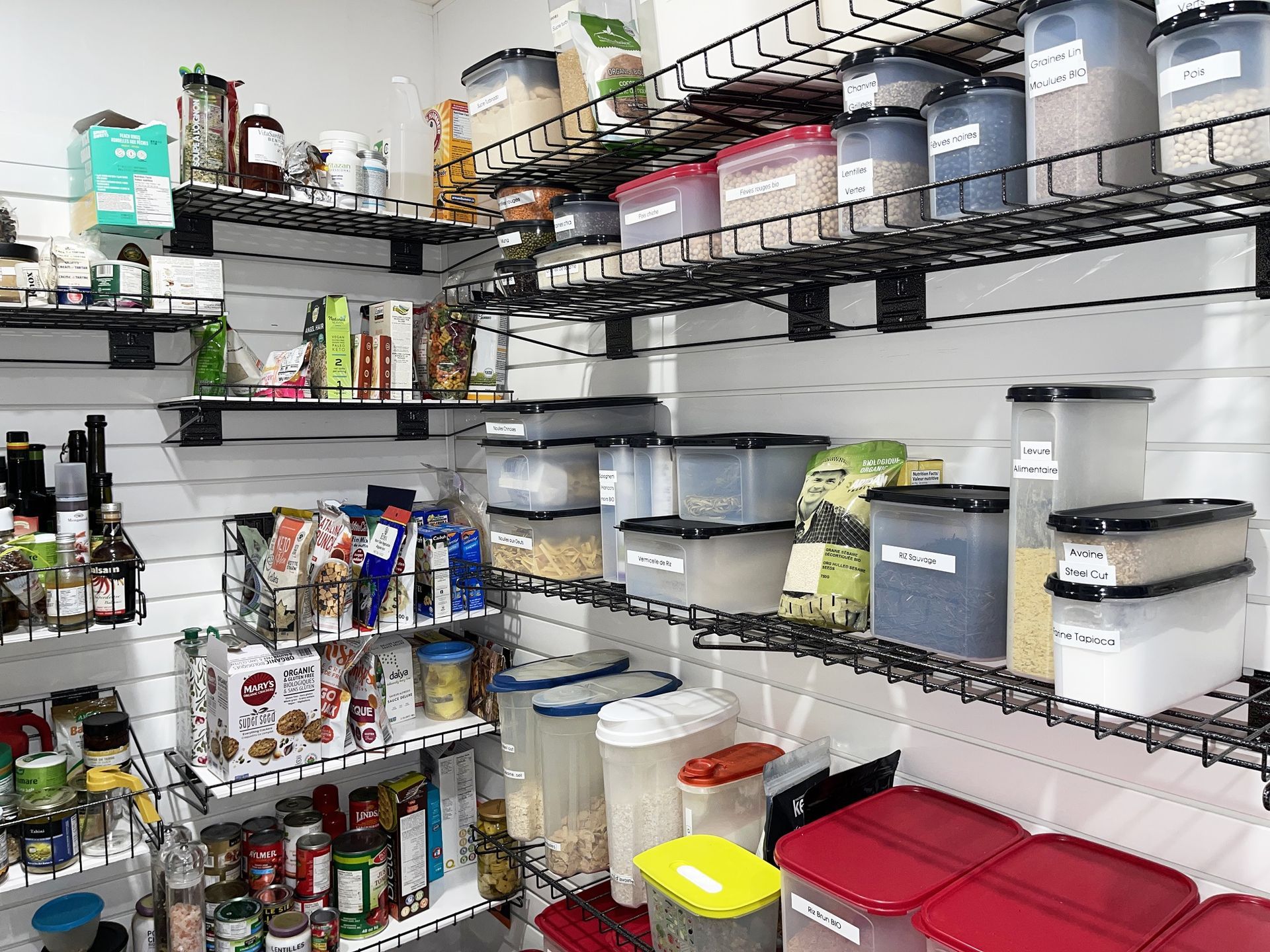 Un garde-manger rempli de beaucoup de nourriture et de récipients.