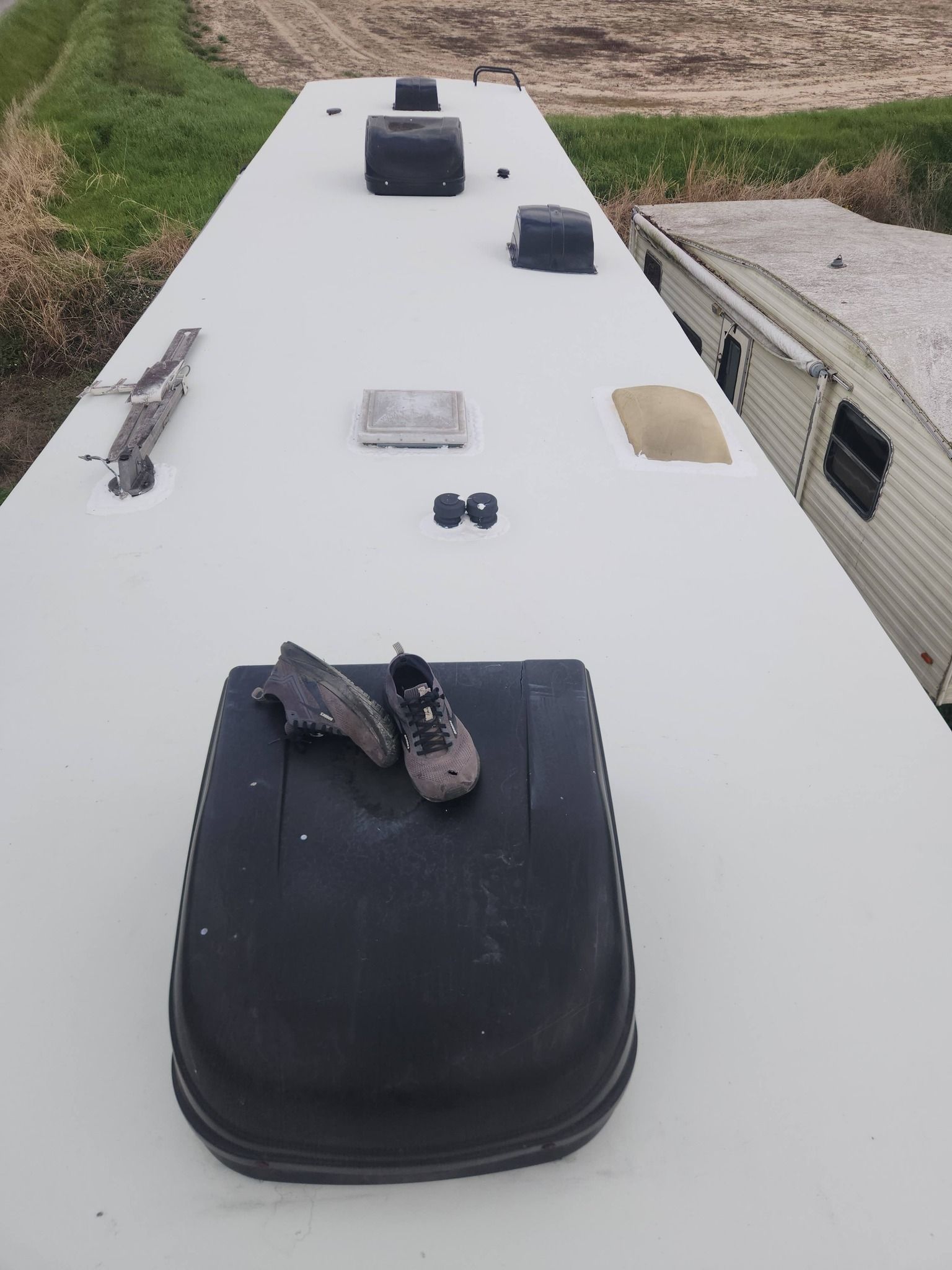 RV rooftop with several vents and roof fixtures on a white camper, viewed from above