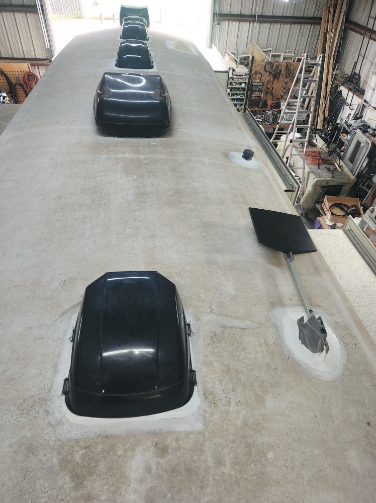 Three black cars parked indoors on a long, light-colored test track or workshop floor