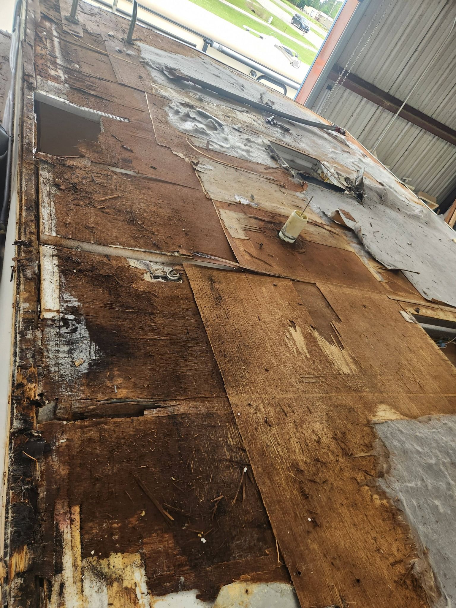 Damaged brown floorboards and peeling paint in a narrow indoor corridor