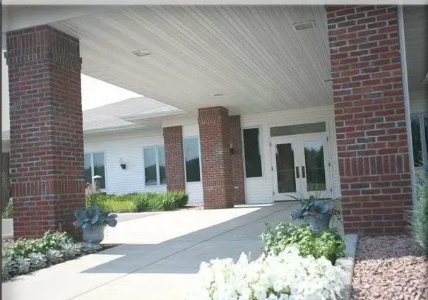 A brick building with a covered walkway leading to the entrance