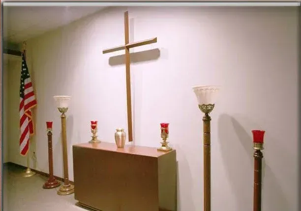 A church with a cross on the wall and candles