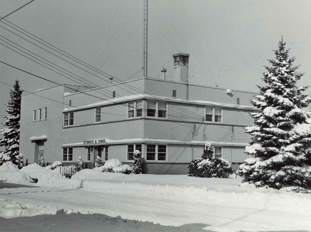 A black and white photo of a building covered in snow