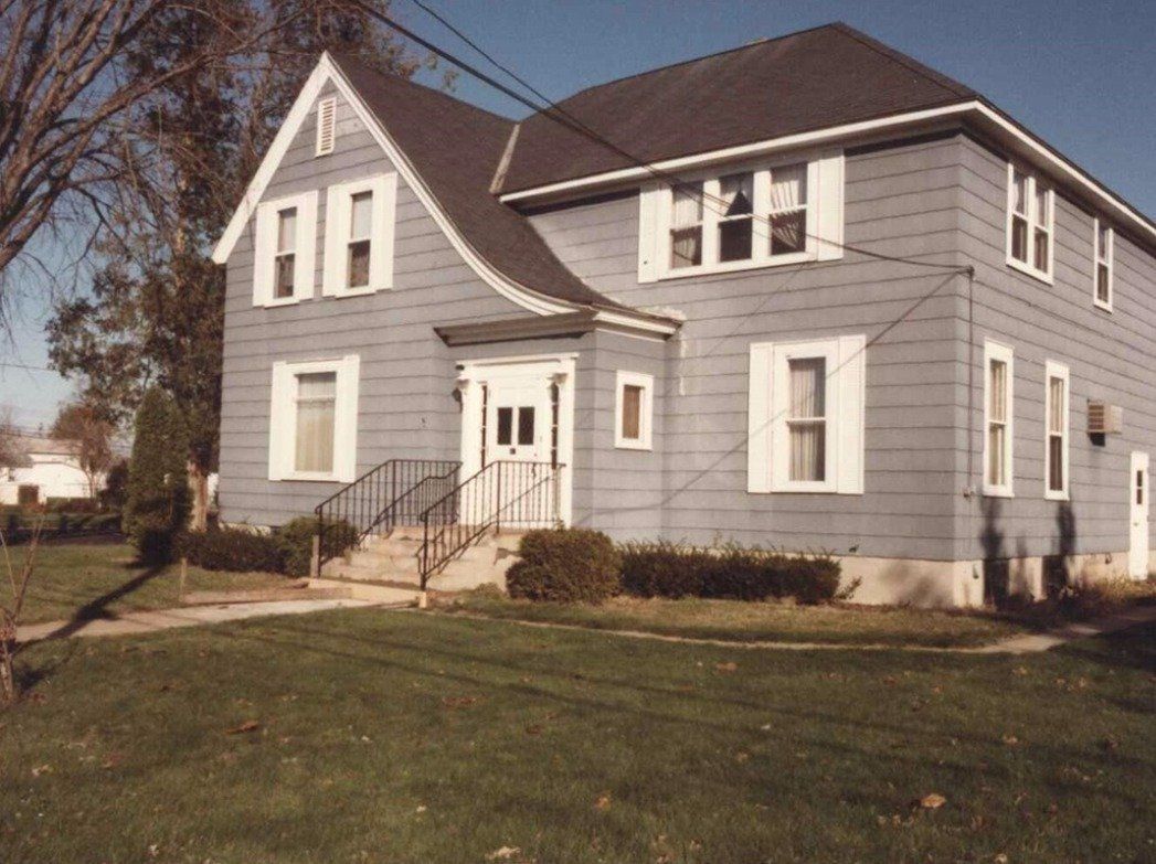 A large gray house with white trim and a black roof