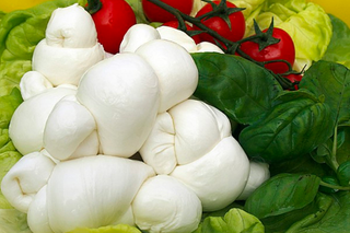 Sei ravioli bianchi al vapore su un piatto bianco, legati in cima e lucidi di umidità