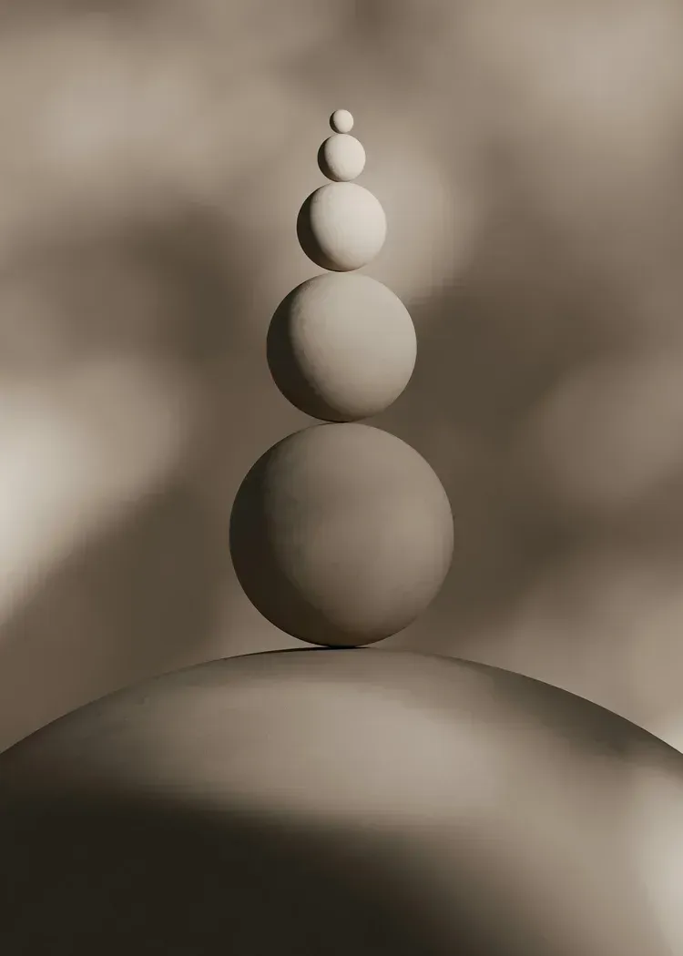 Stacked spheres on a curved surface against a blurred sepia background