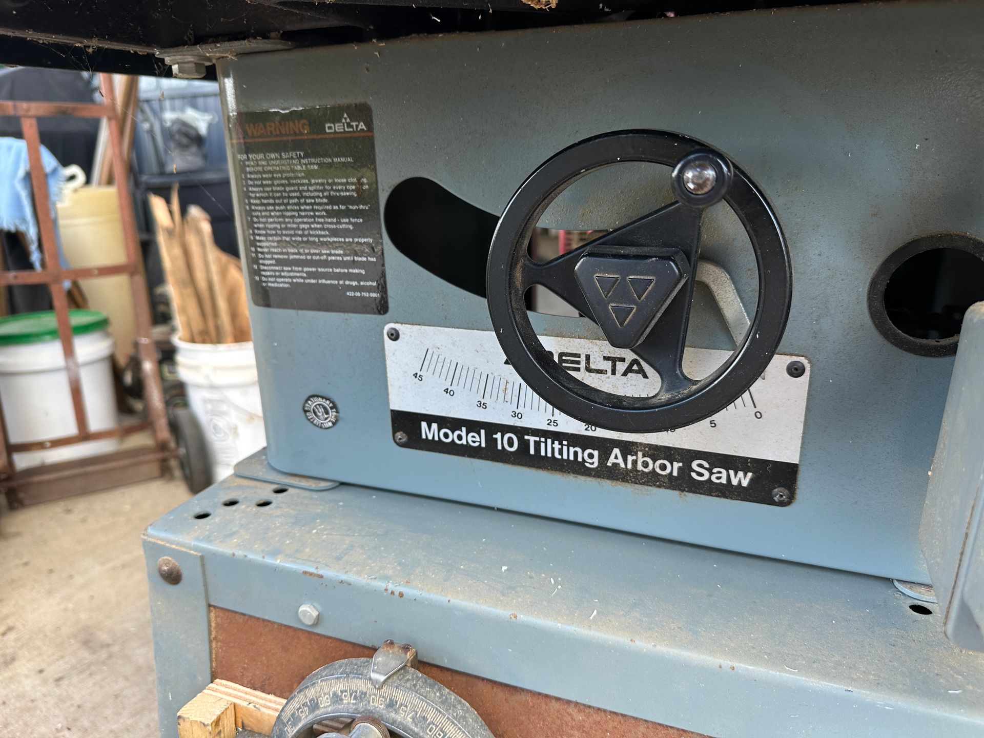 Gray machine panel with a black handwheel and label reading “World 10-Ting Arbor Saw”