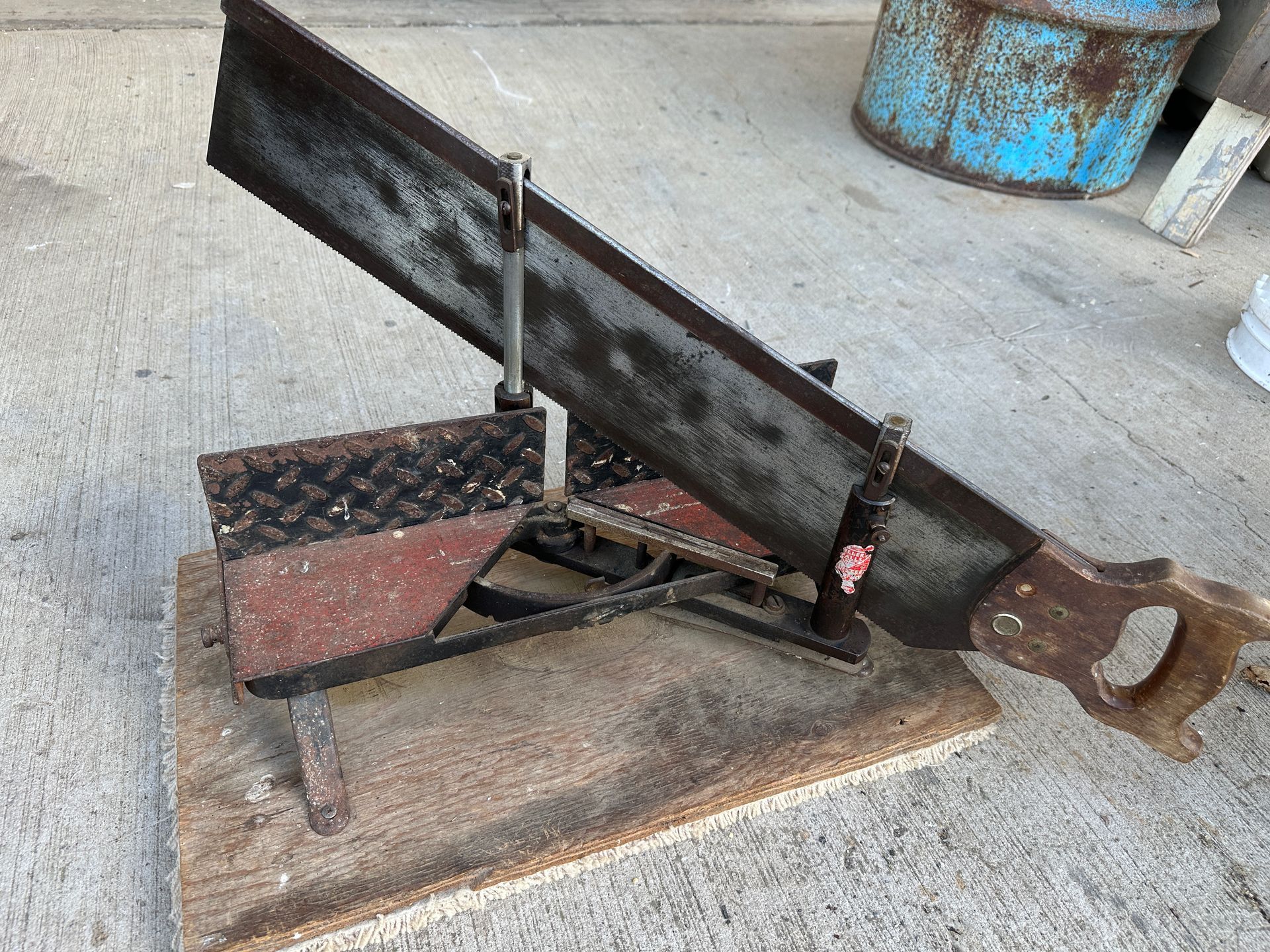 Rusty tow hitch with jack and chains on a concrete surface, beside a large metal beam