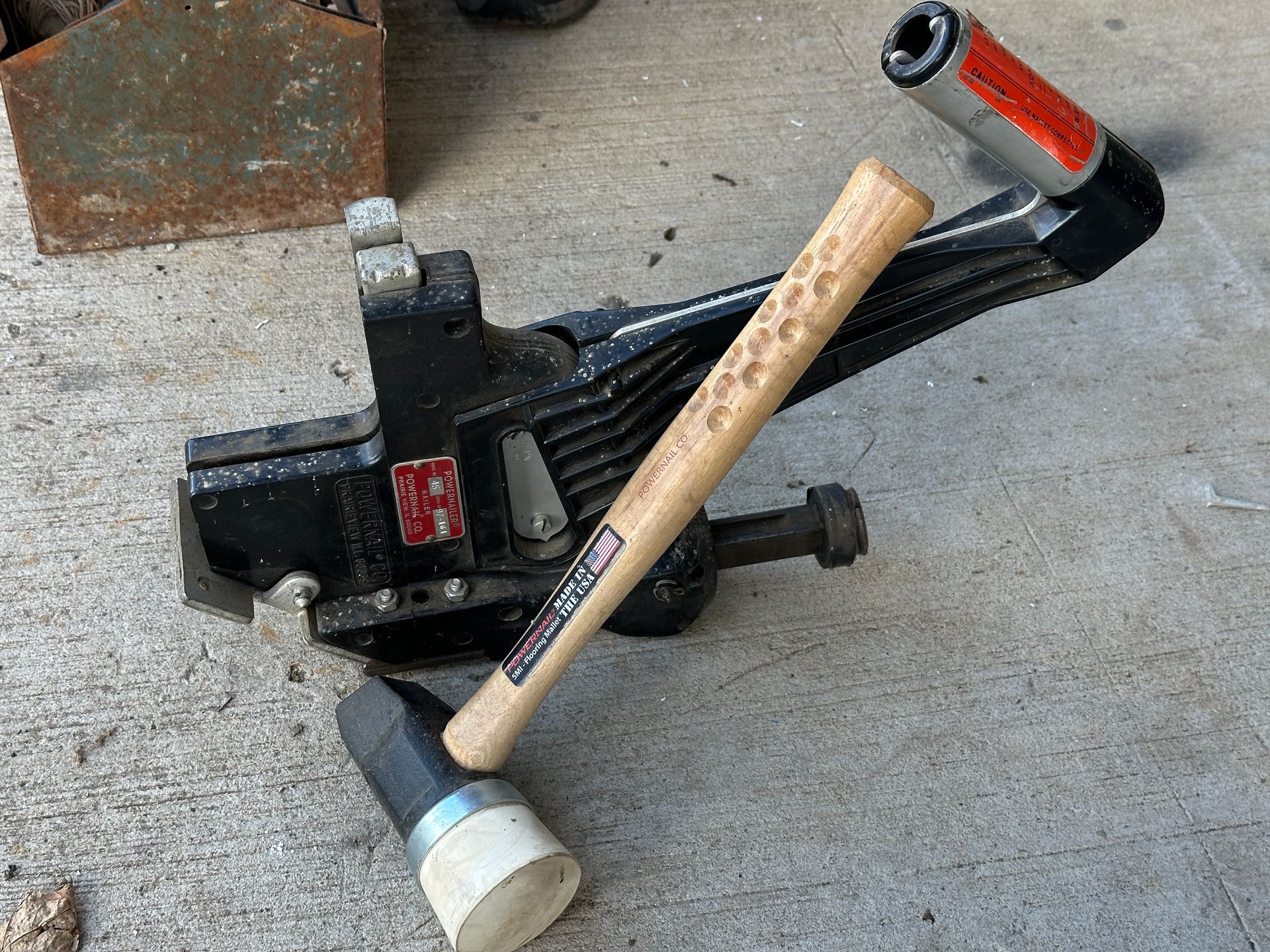 Broken jack and hammer lying on concrete floor with a brick nearby