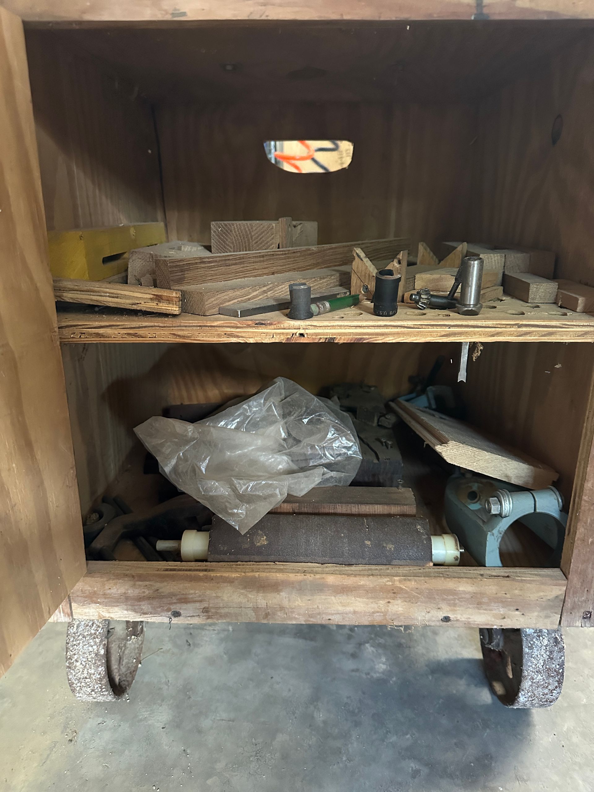 Wooden cart filled with assorted scrap metal and hardware on caster wheels