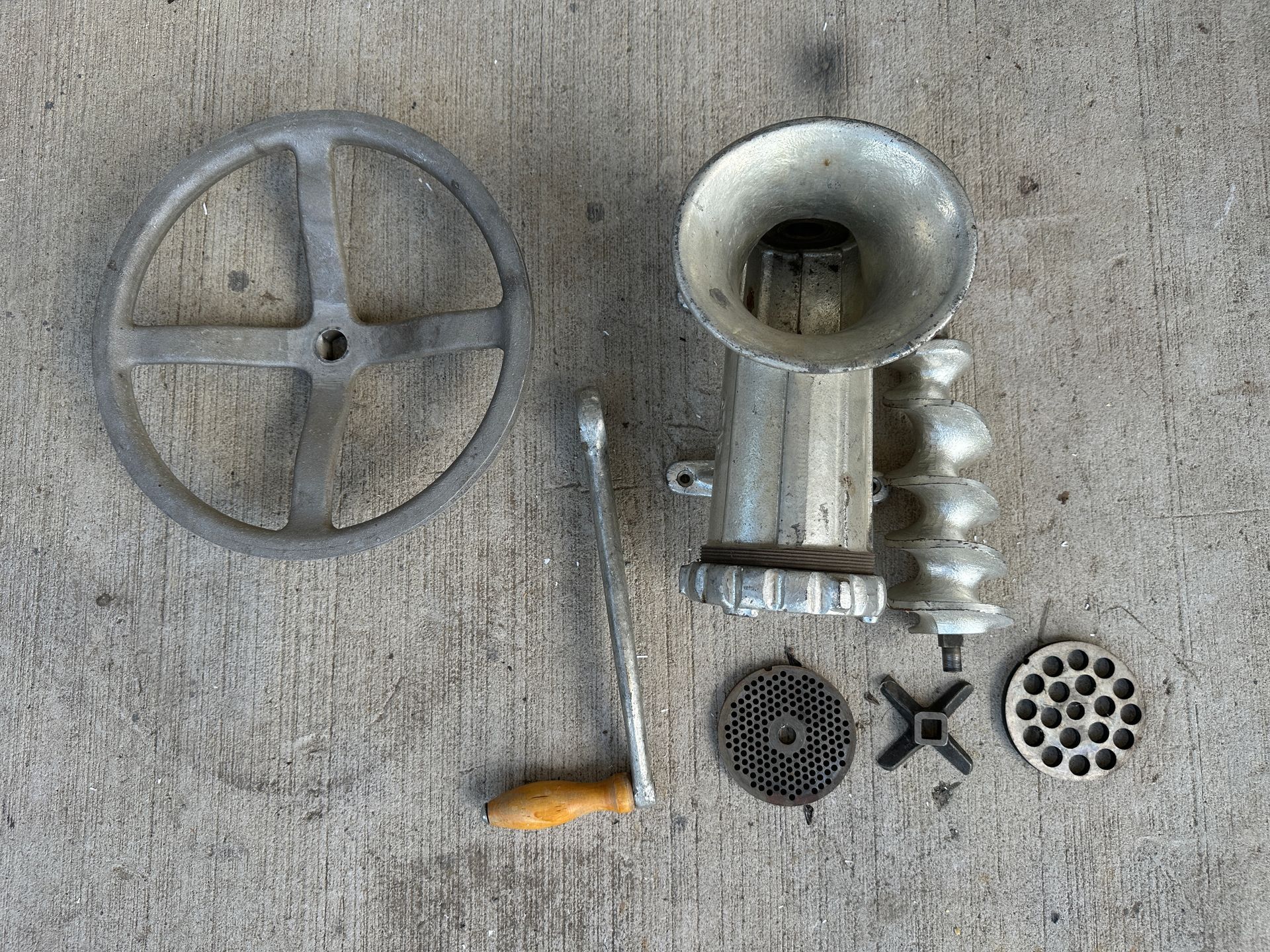 Assorted metal machine parts and fittings laid out on a gray surface.