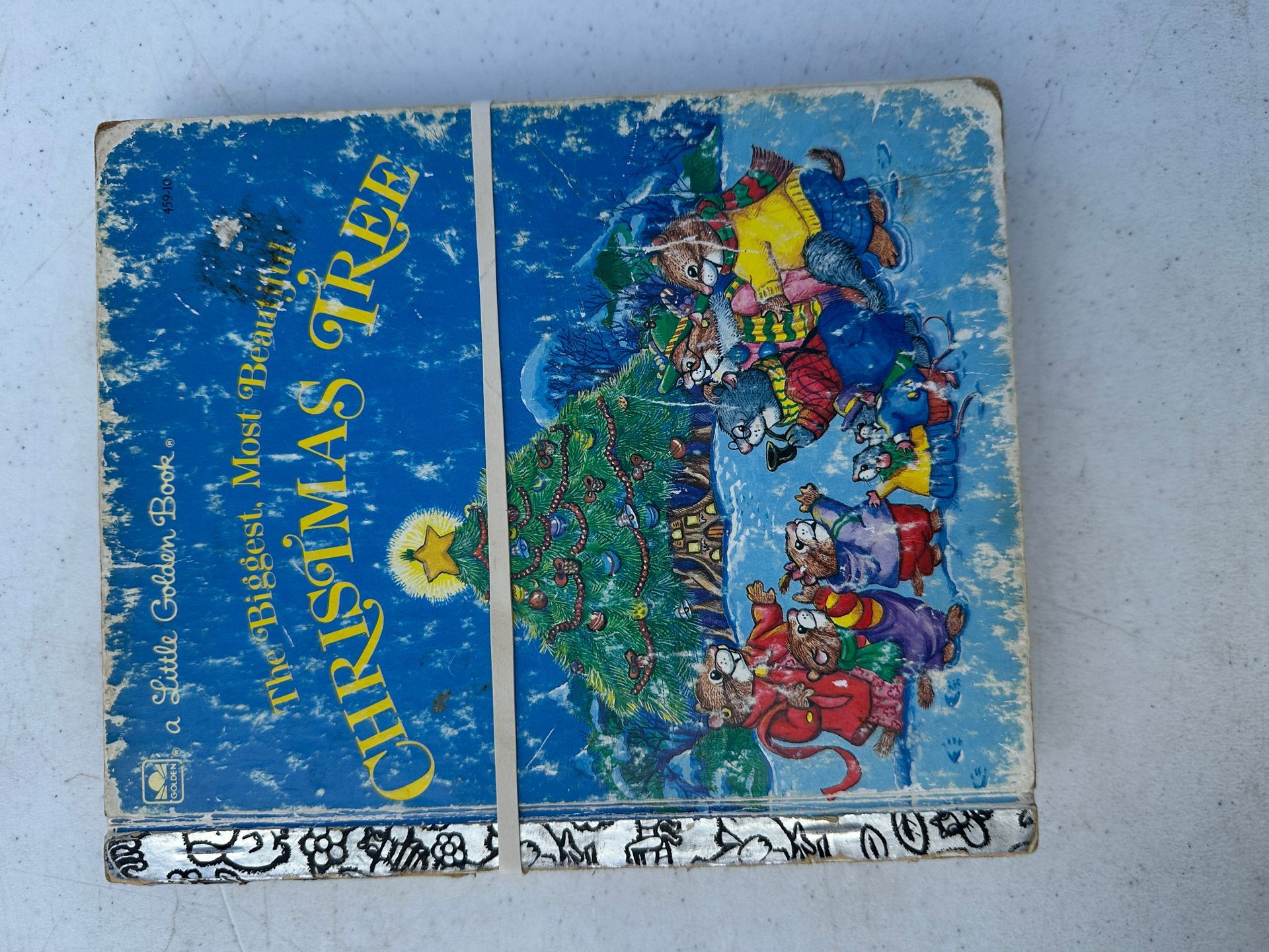 Blue cover with yellow text and a colorful illustration of a house and people, worn and scratched.