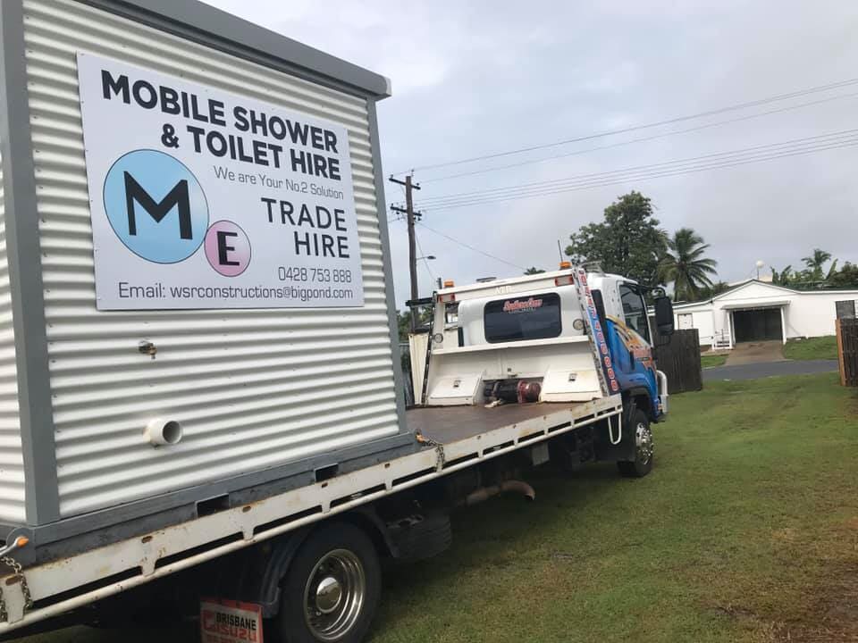 A Mobile Shower and Toilet Hire Truck is Parked in a Grassy Field — Southern Cross Tilt Trays in Andergrove, QLD