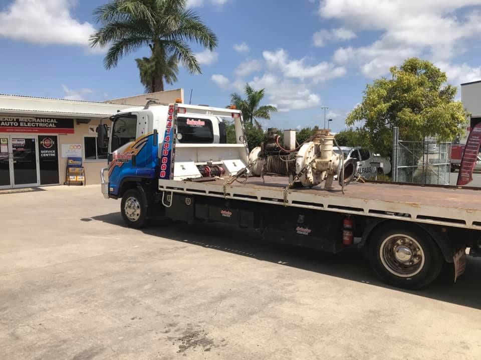 Flatbed Tow Truck Parked Outside a Building — Southern Cross Tilt Trays in Bowen, QLD
