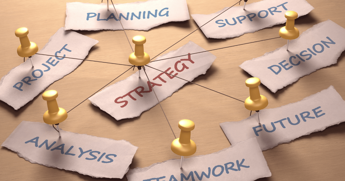 Paper labels around pins forming a planning strategy network on a beige surface