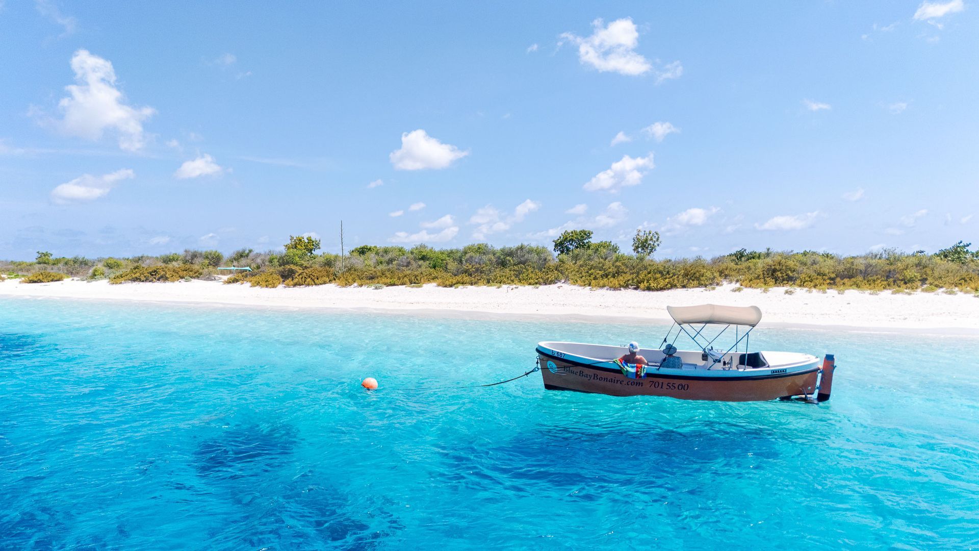 Blue Bay Bonaire boot verhuur, oranje sloep ligt te dobberen aan een boei voor Klein Bonaire