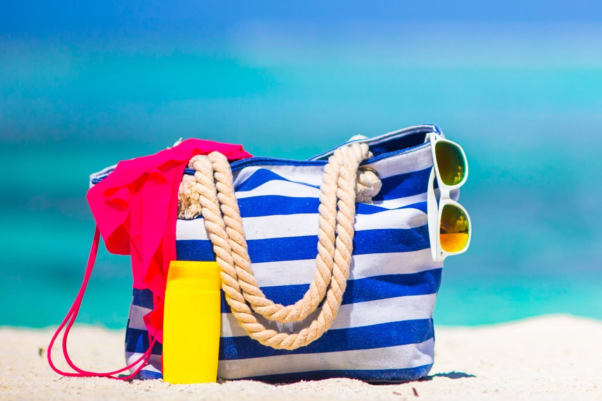 Strandtas met een zonnebril, zonnebrand spul en een bikini topje | Bootverhuur Bonaire