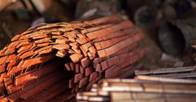 Tejas de terracota apiladas y agrupadas en un taller, con un montón desenfocado en primer plano