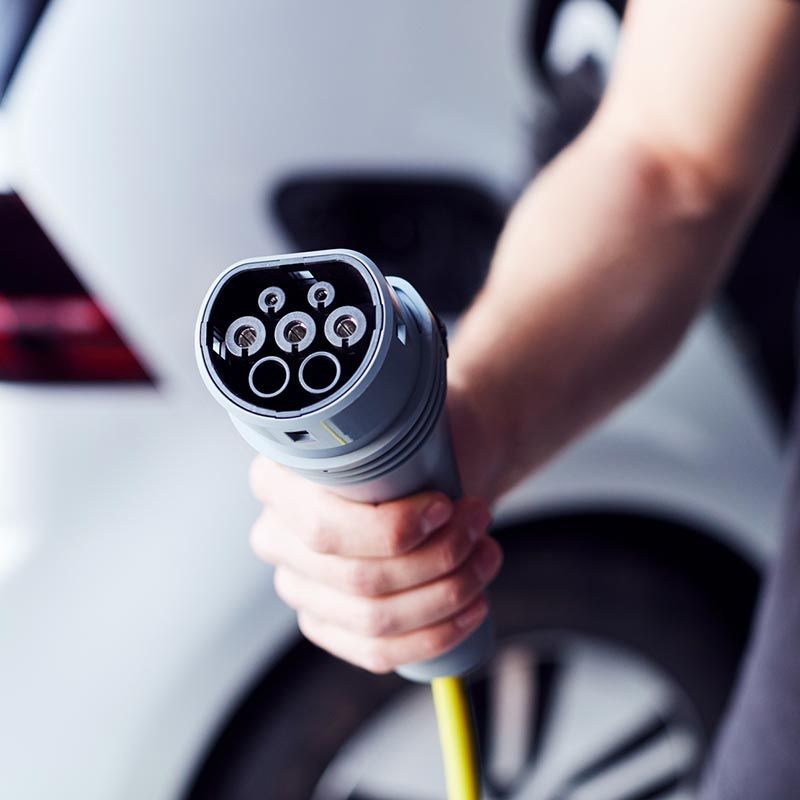 A person is charging an electric car with a charger