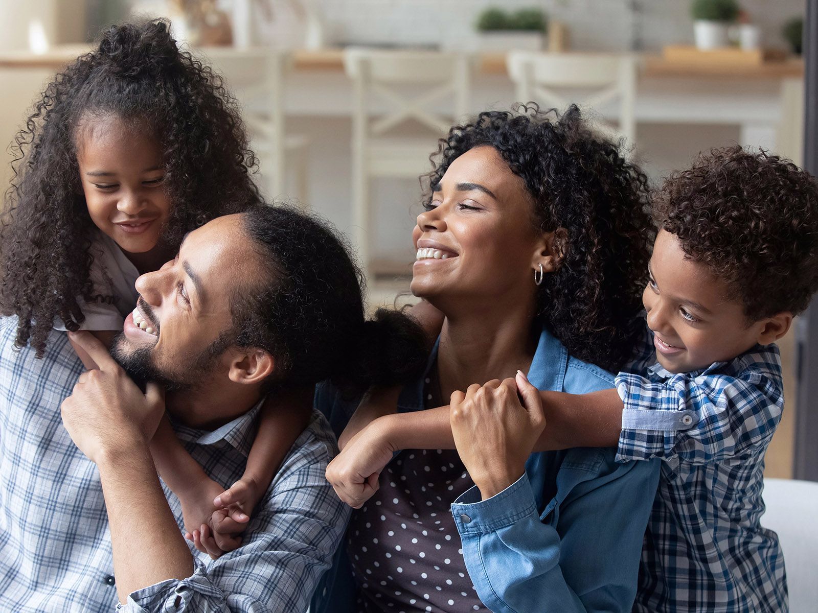 A family is sitting on the floor in a living room.
