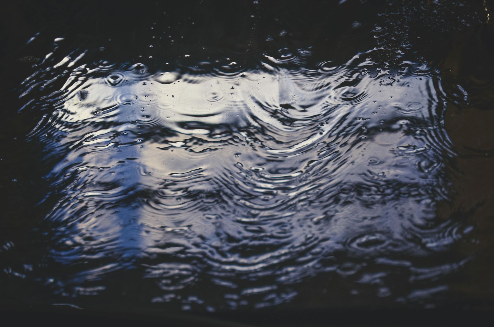 Rippling dark water with shimmering white and blue reflections