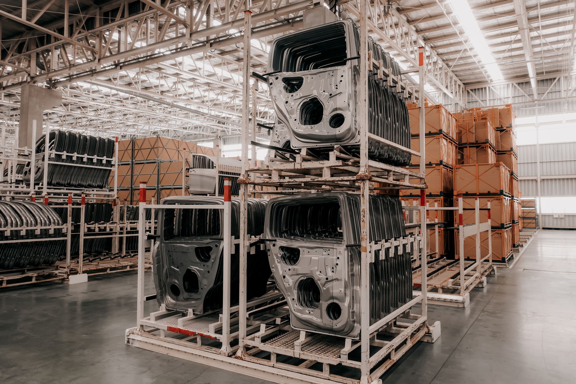 Warehouse aisle with stacked metal parts and cardboard boxes on storage racks